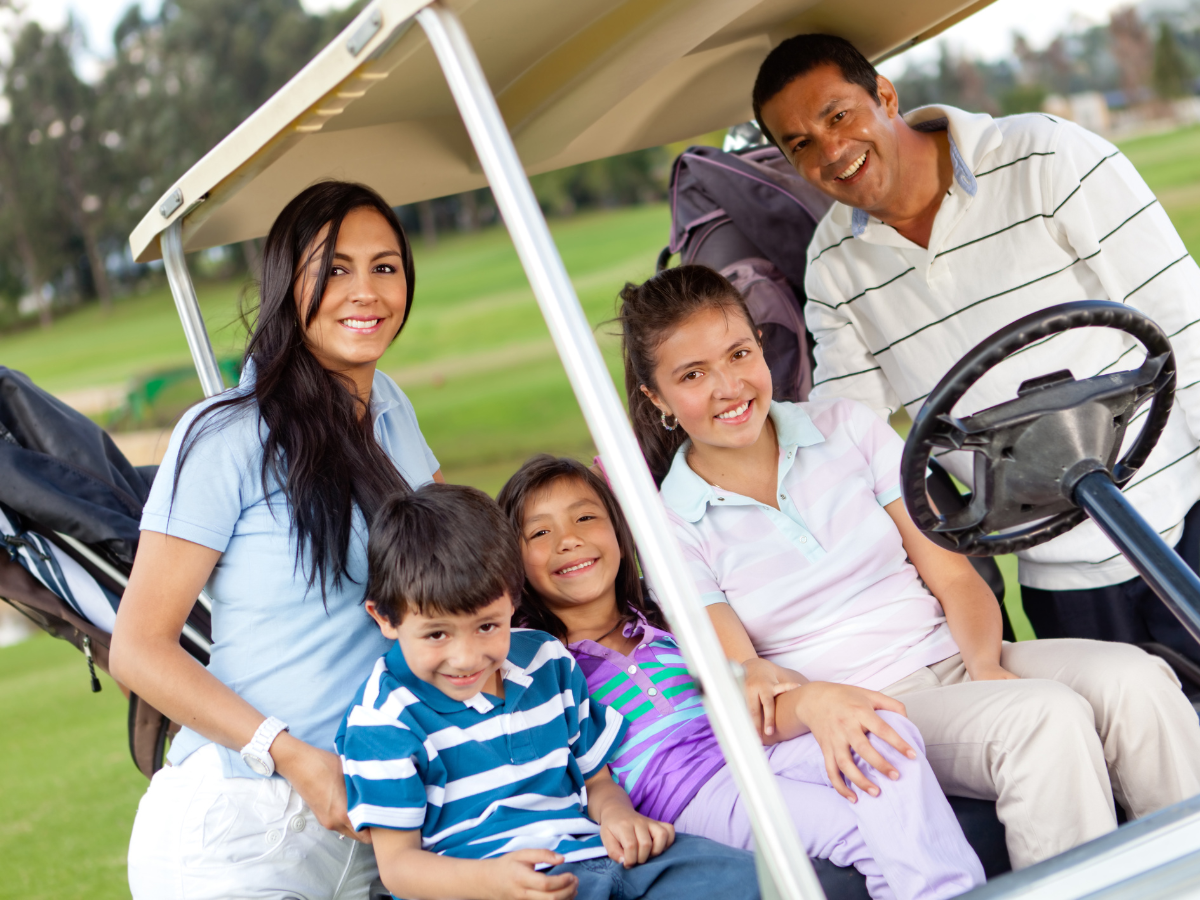 family riding in a golf cart - outdoor sports like golf are great for boys and girls of any age 